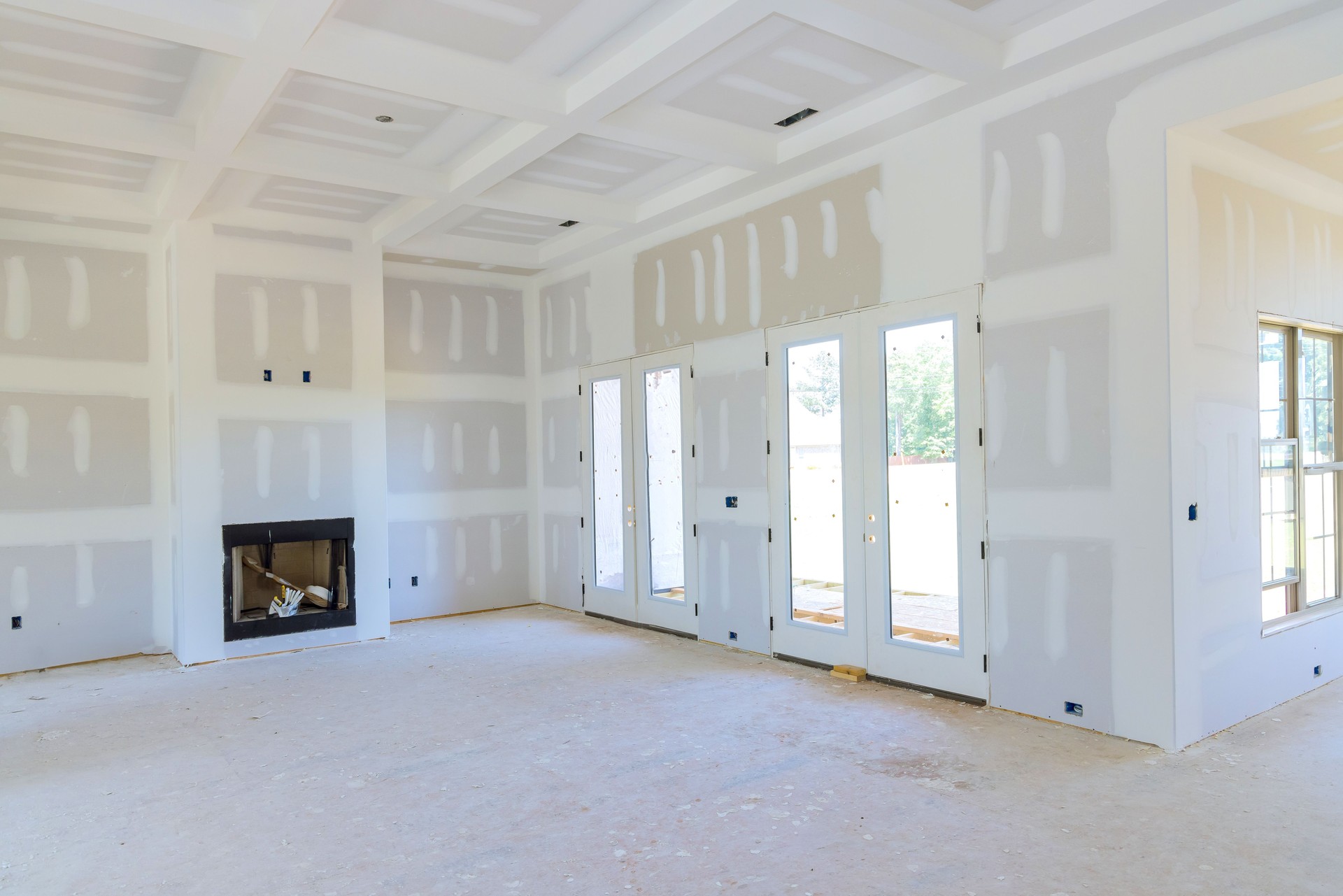Plastering drywall in preparation for painting in a newly constructed house