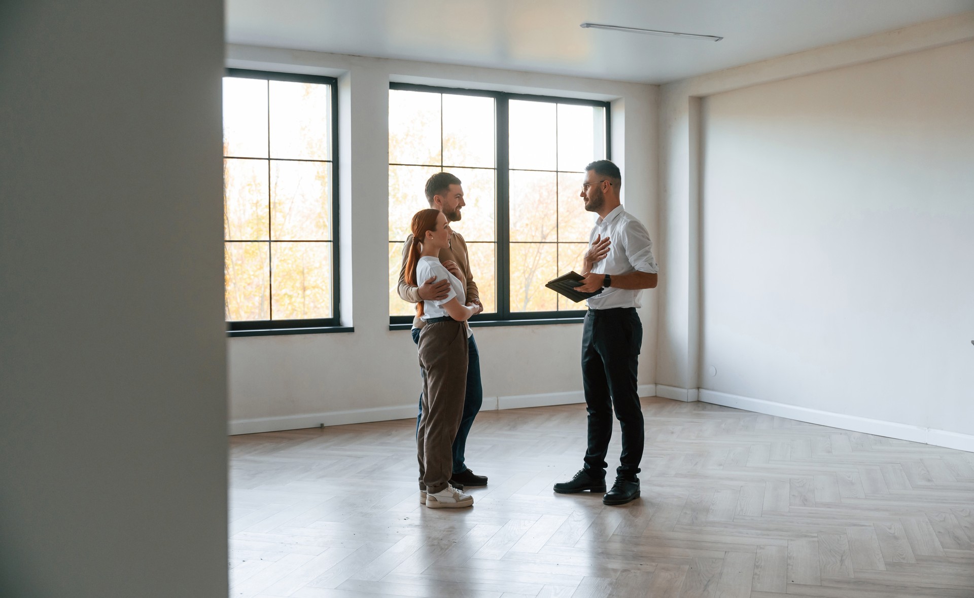 Empty room. real estate agent shows an apartment to a young couple