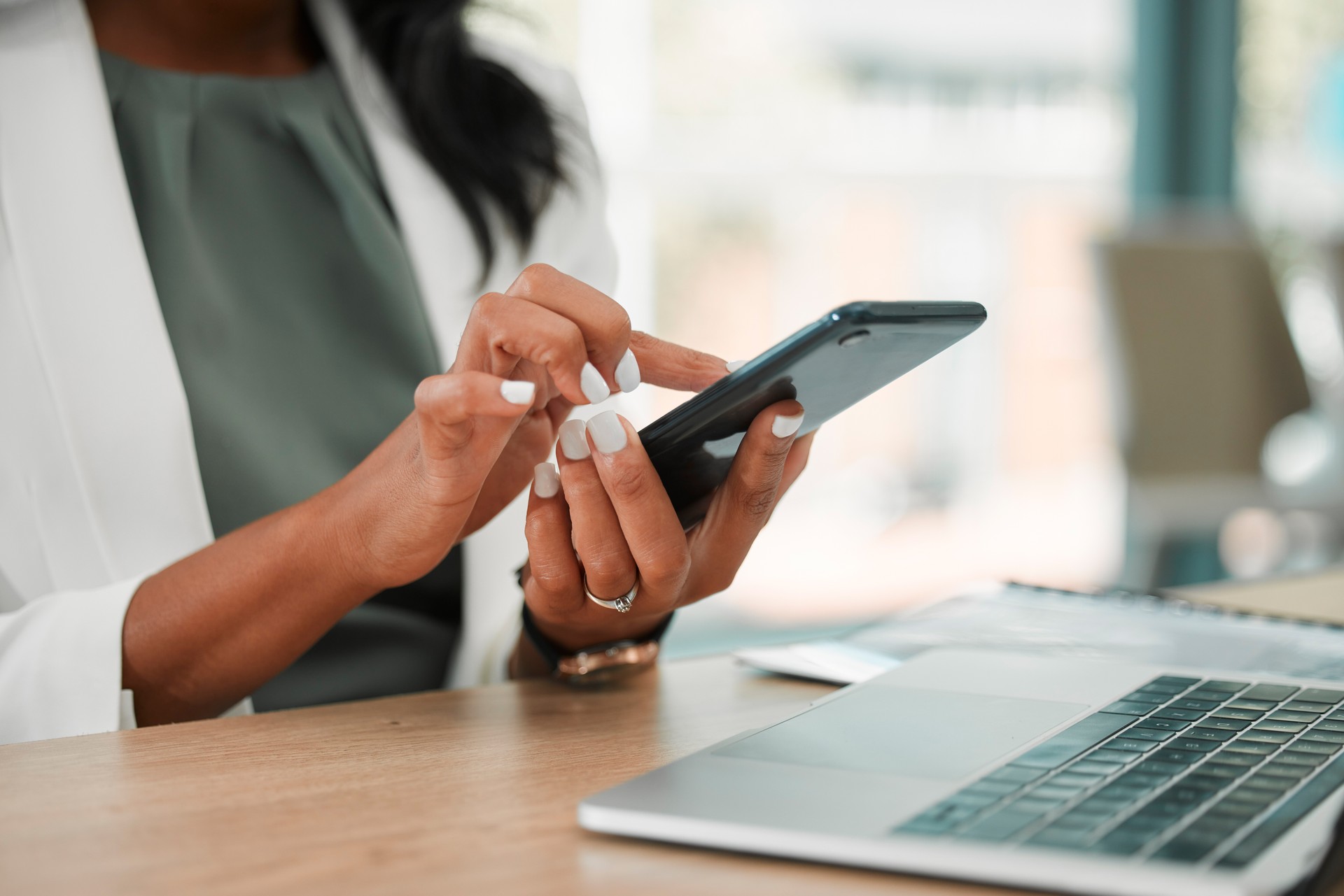 Phone, office and business woman networking on social media, the internet or a mobile app. Technology, corporate and professional company leader browsing on a mobile device in her modern workplace.